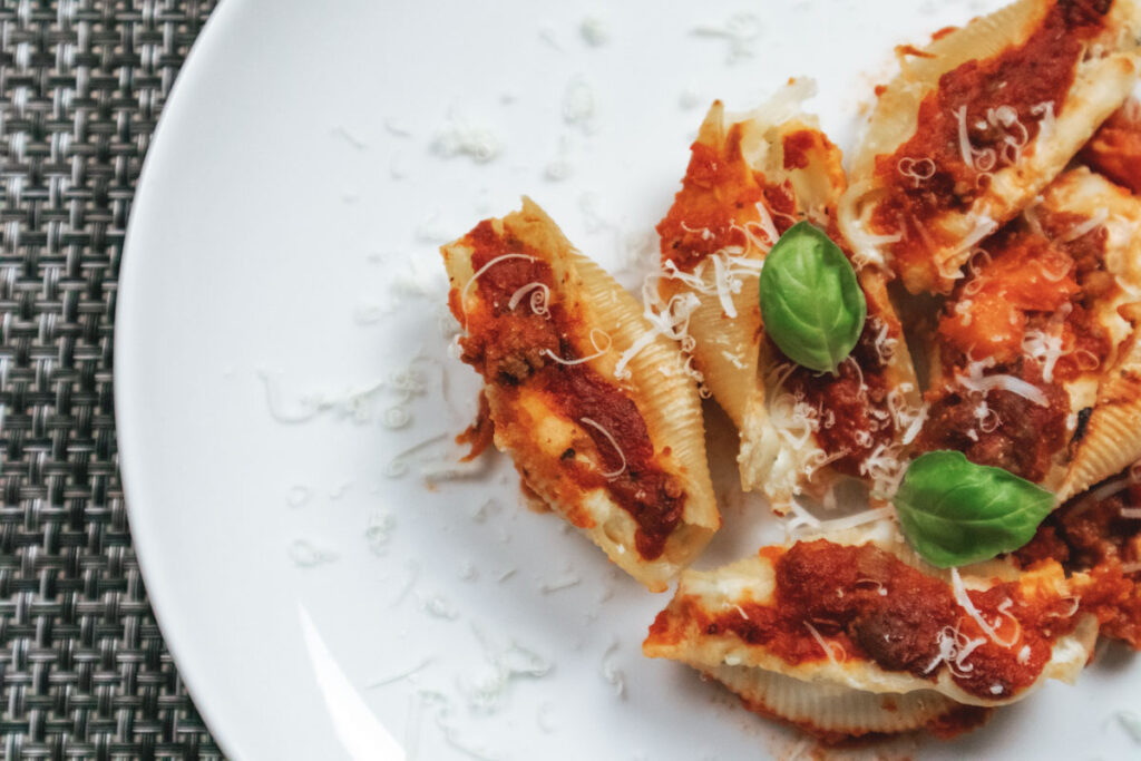 Conchiglioni ripieni al forno con ricotta su piatto bianco.